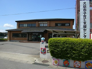 茶色の壁で正面委入り口がある二階建ての建物の写真
