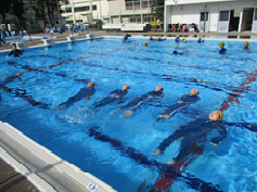 プールにあおむけになって浮かんでいる子供たちの写真