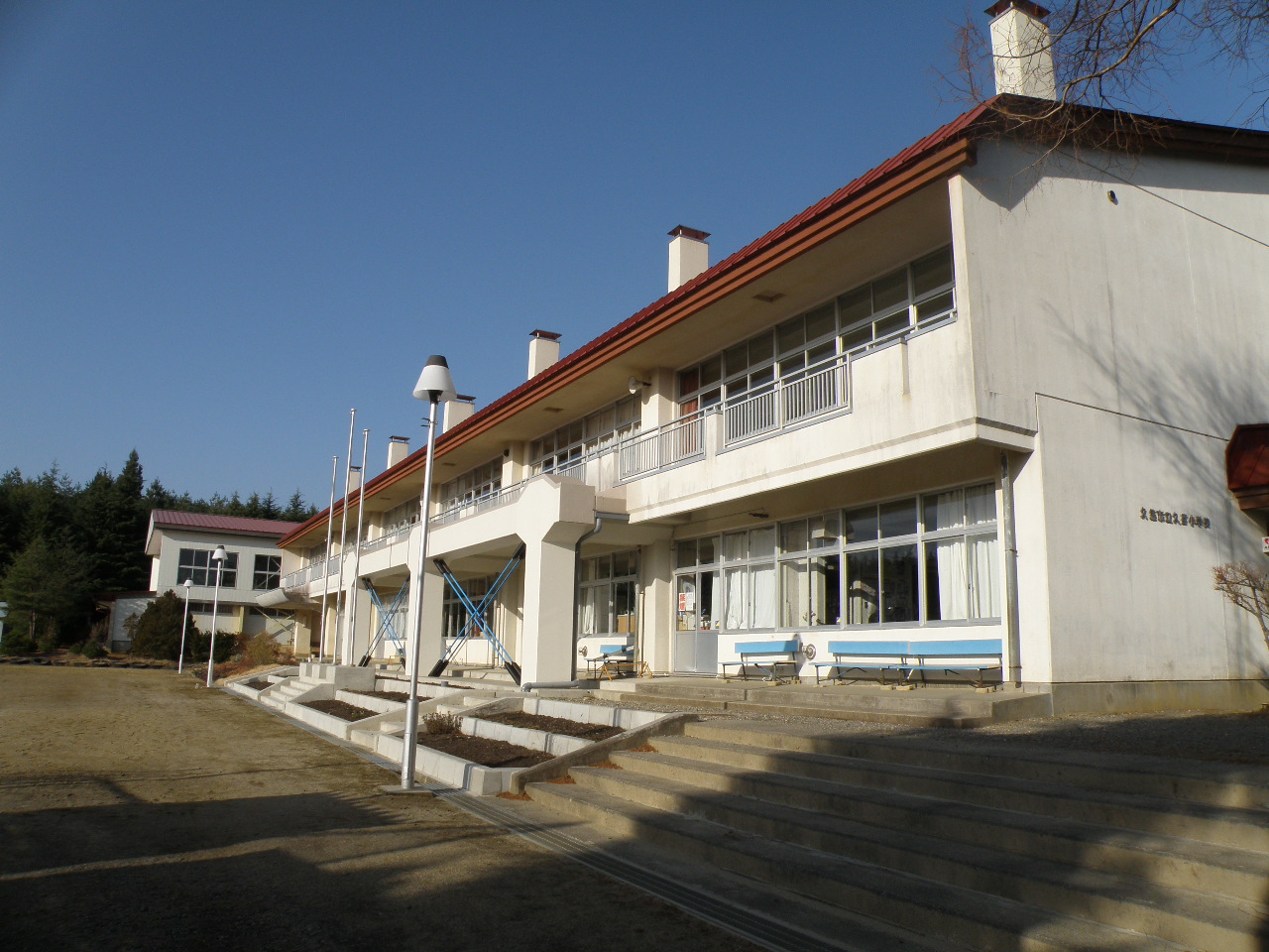 赤い屋根に2階建ての校舎を斜め横から撮影した写真