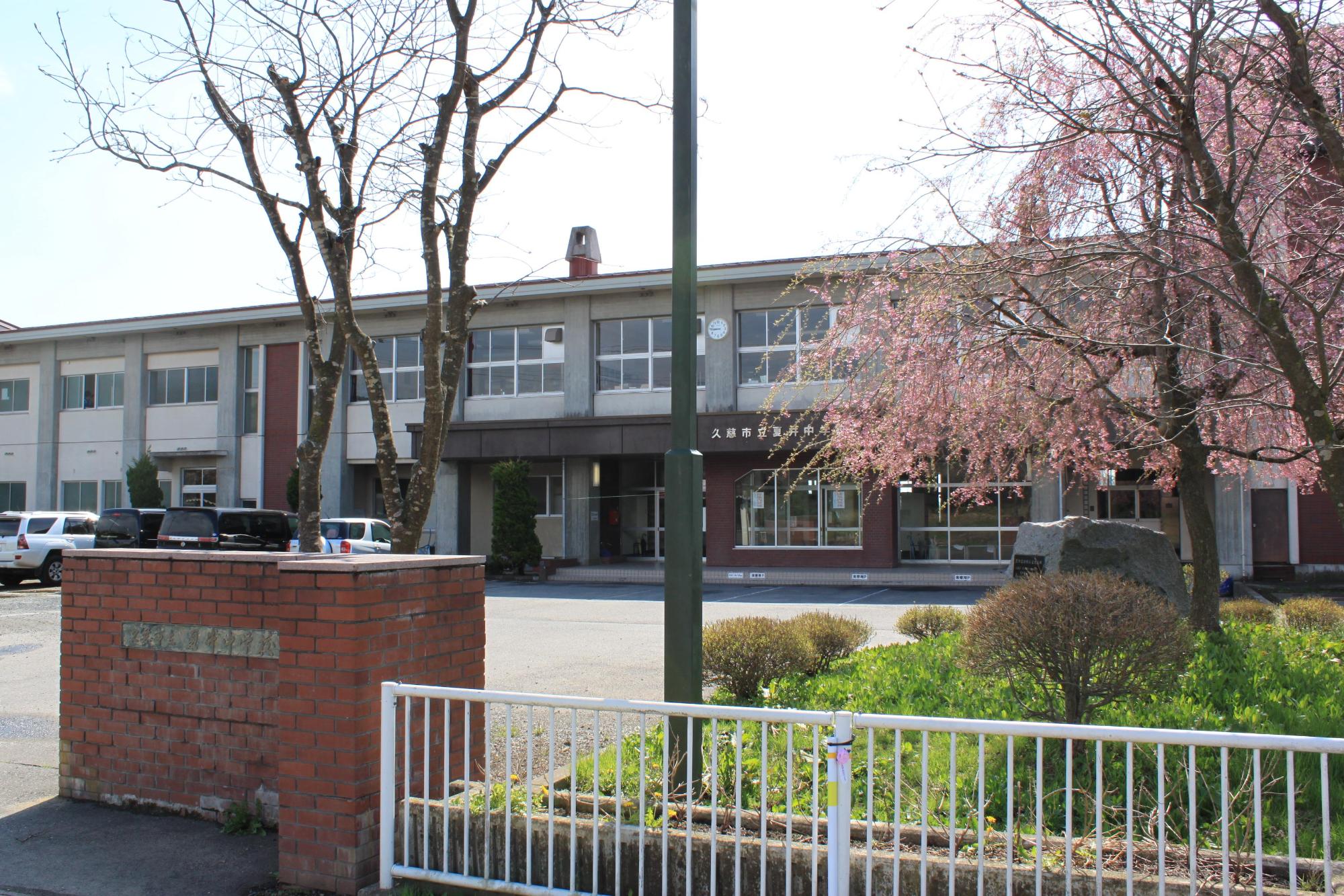 枝垂桜の奥に2階建て校舎が建っている写真