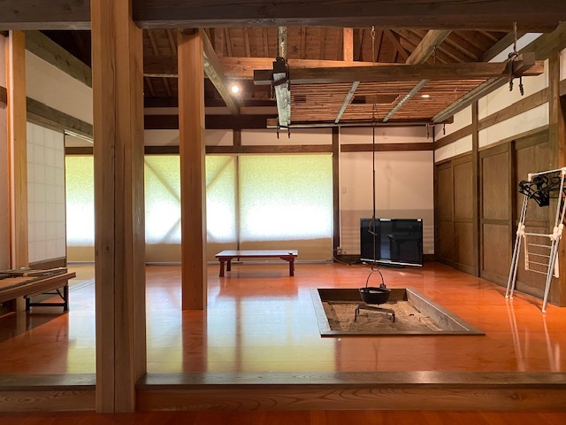 木造家屋の中に囲炉裏やテレビが設置されている写真