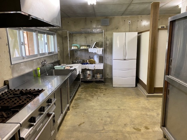 食器棚や冷蔵庫が置かれた厨房の写真