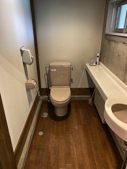 木目調の床に洋式トイレが設置されている写真