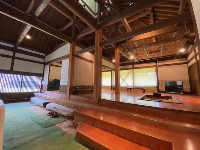 木造家屋の玄関から和室の入り口や囲炉裏のある居間が見える写真