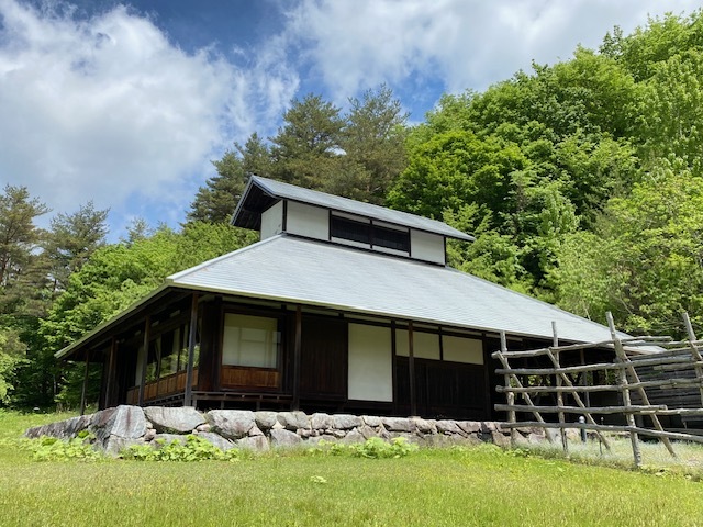木々に囲まれた木造家屋の写真