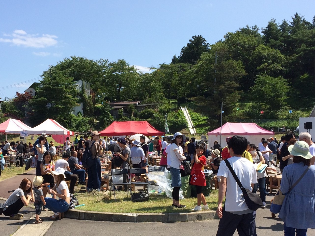 イベント用テントが立てられた広場に大量の人が集まっている写真