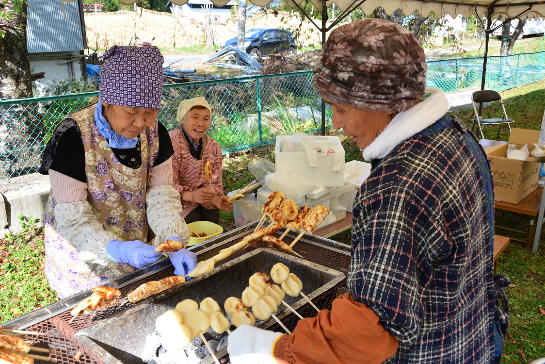 お年寄りの方が郷土食を焼いている写真