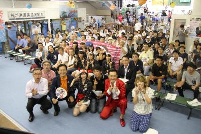 大勢の人がカメラに向かって撮影するカメラを見たりポーズをとっている写真