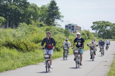 海女の格好をした人がサイクリングをしている写真