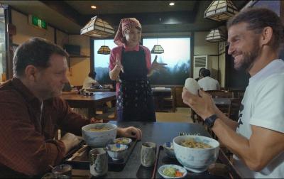 飲食店で店員の説明を聞いている外国人2人の写真