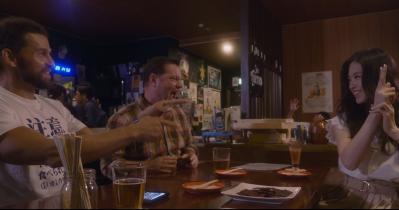 バーのテーブルで飲んでいる男女の写真