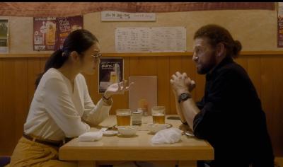 飲食店のテーブルで向かい合って話をしている男女の写真