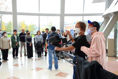 白を基調とした屋内の広場に大勢の人が集まっている写真