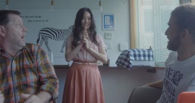 印を結んでいる女性に驚いている男性2人の写真