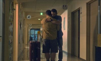 廊下で2人の男性が抱き合っている写真