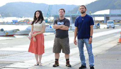 港で男女3人が並んで立っている写真