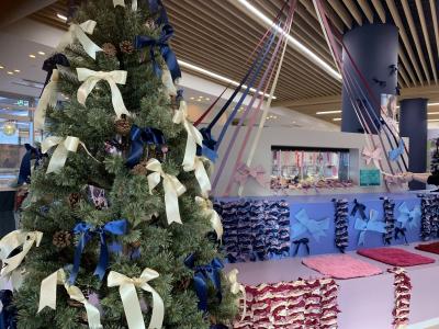 クリスマスツリーに白色と紺色のリボンが括り付けられている写真