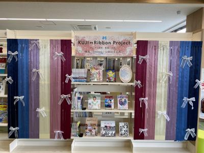 複数の本が表紙を向けて並べられている周りにリボンの装飾がされている写真