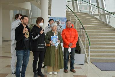 すぐ隣に階段のある館内で複数の人が立っている写真