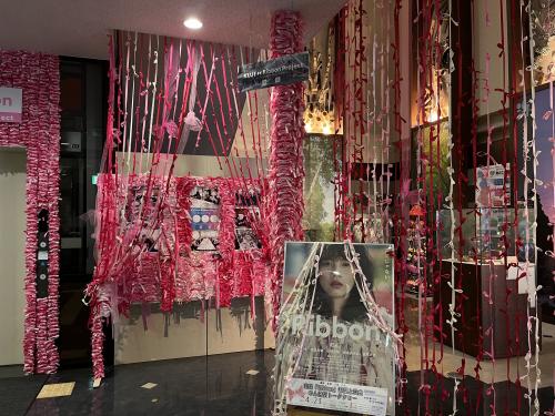 屋内の一角が赤色やピンク色や白色のたくさんのリボンで飾られている写真