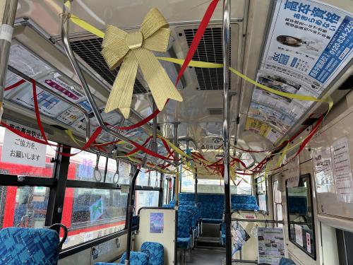路線バス中の上部が黄色や赤色のリボンで飾られている写真