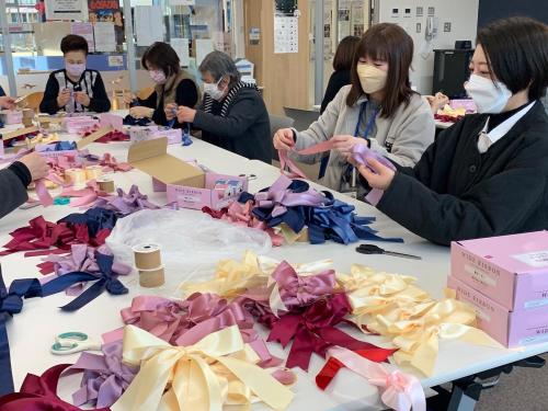 女性たちが作ったリボンがたくさん置かれている写真