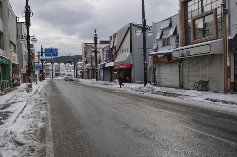 歩道が雪に覆われた商店街の写真