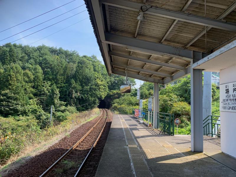 下に降りる階段が設置された駅のホームの写真