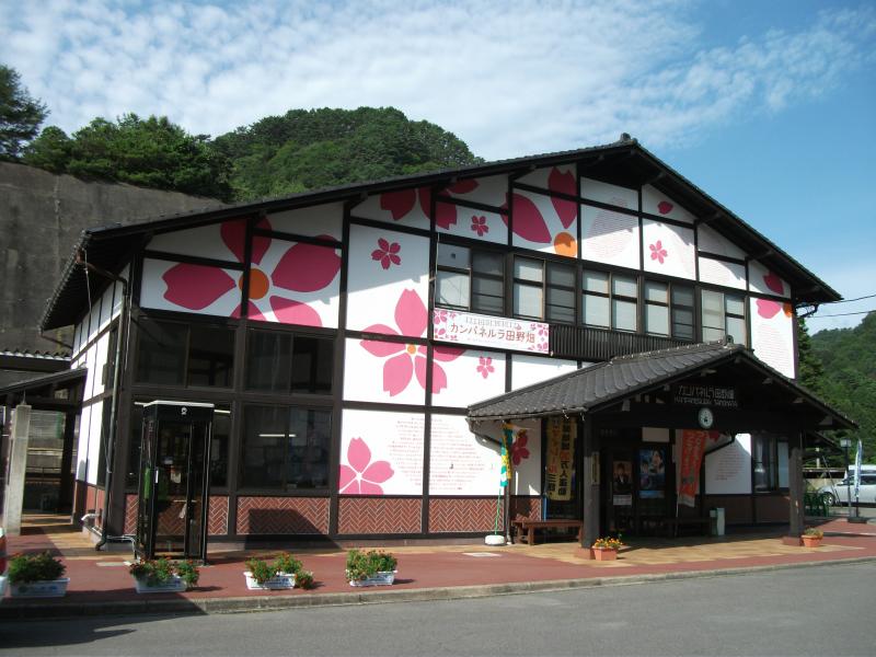 サクラの花びらが描かれた2階建てで三角屋根の建物の写真