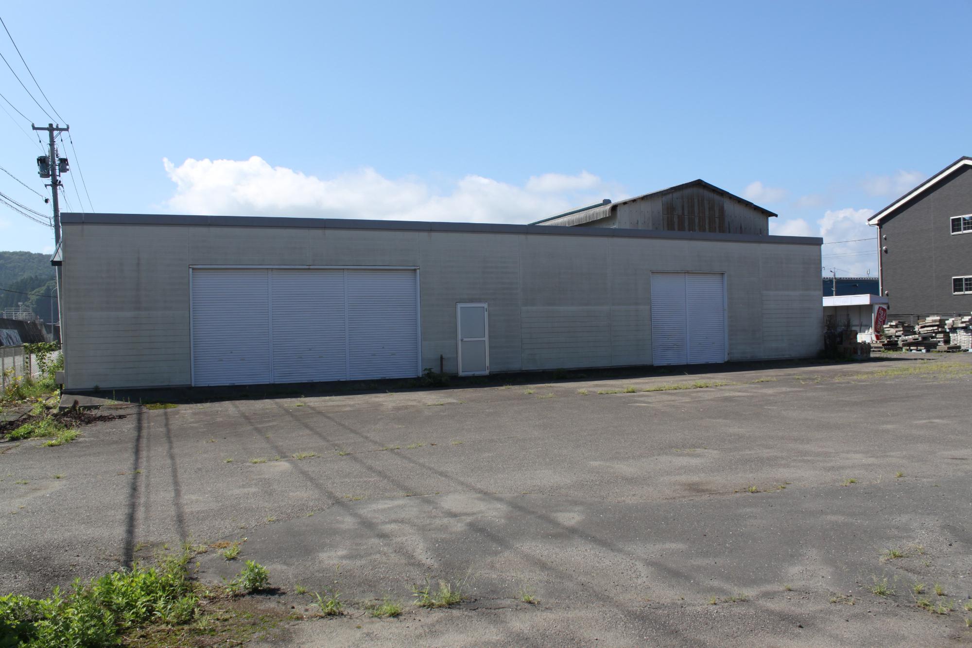 横幅の広い建物のにシャッターが2つ付いている写真