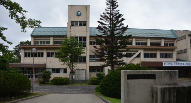 青緑色の屋根をした3階建ての校舎の写真