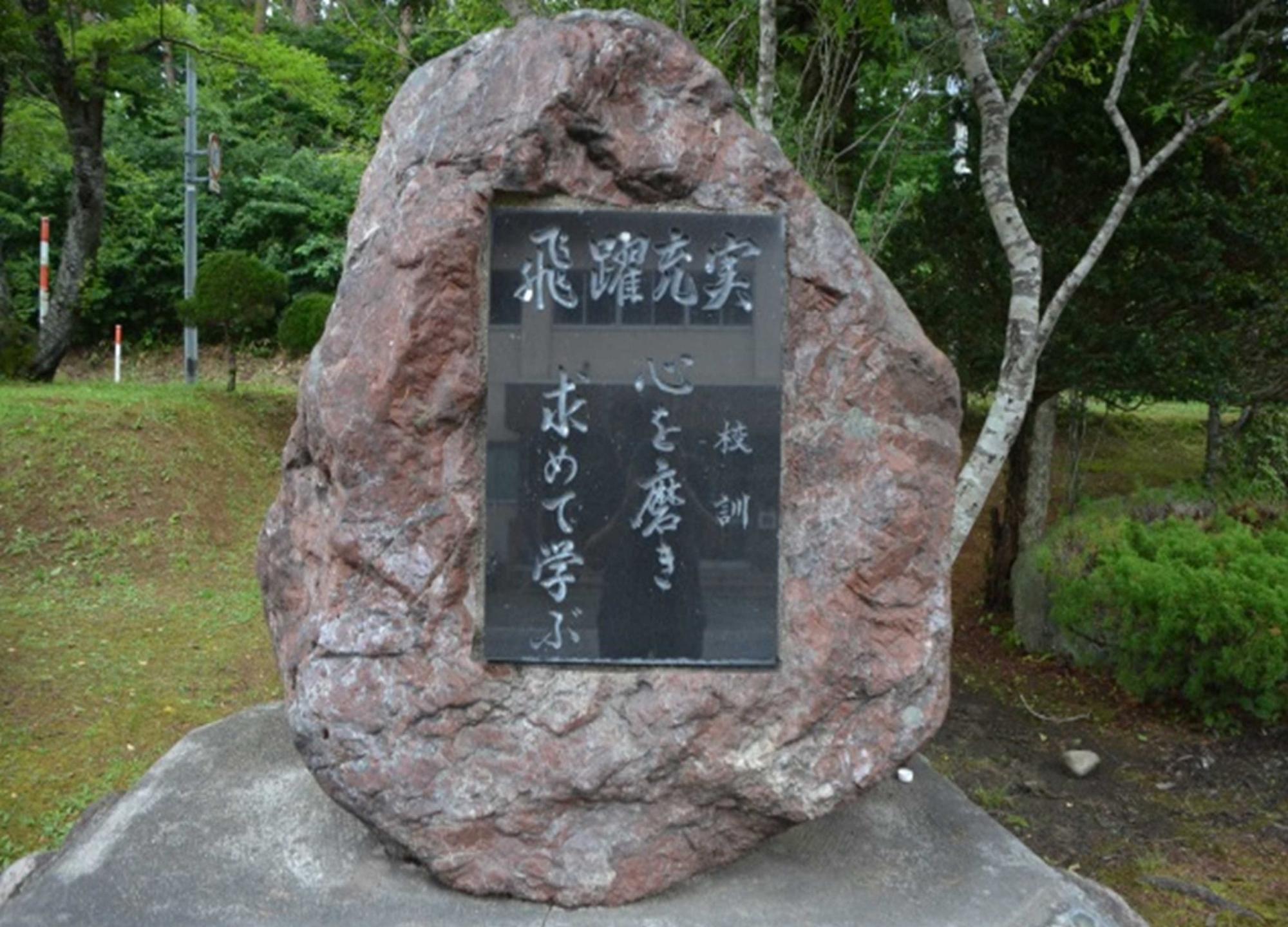 野外に置かれた校訓の書かれた石碑の写真