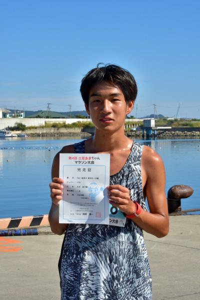 タンクトップ姿の男性が完走証を手に持っている写真