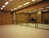 広い室内の1面にガラスが備え付けられた練習室の写真