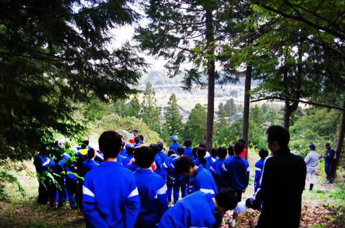 ジャージ姿の生徒たちが山の中を歩いている写真