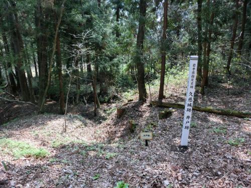 「久慈城跡 井戸跡」と立札のある森の写真