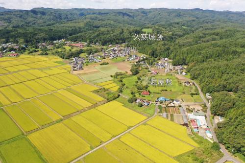 山と田んぼの広がる土地に「久慈城跡」と「堀屋敷」と「堀川」と「たな場」の位置が示された写真