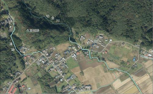 点々と建つ建物や山、畑のある土地の航空写真