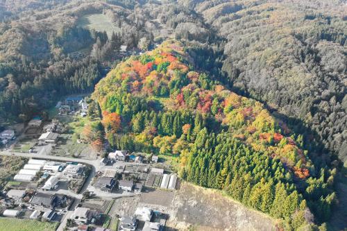 一部分の木々が鮮やかに彩色した山々を上空から撮影した写真
