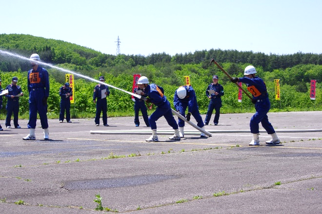 消防団員がホースを持って水を噴射している写真