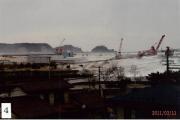 防波堤を超え。住宅側に流れてきている波の写真