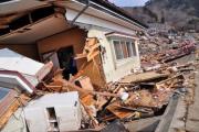 半分が完全に壊れ、残った半分も傾いている家屋の写真