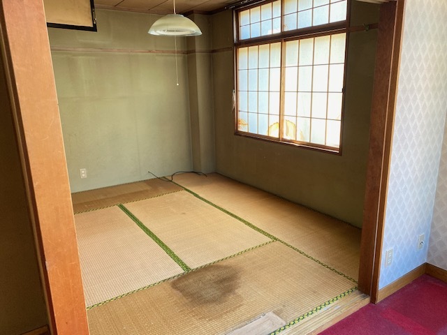 手前の畳に大きなシミの付いた和室の写真