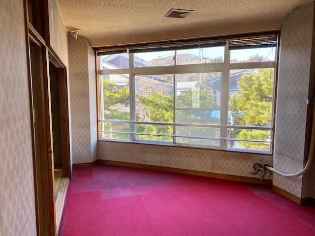 真っ赤な絨毯に壁一面に大きな窓の付いた部屋の写真