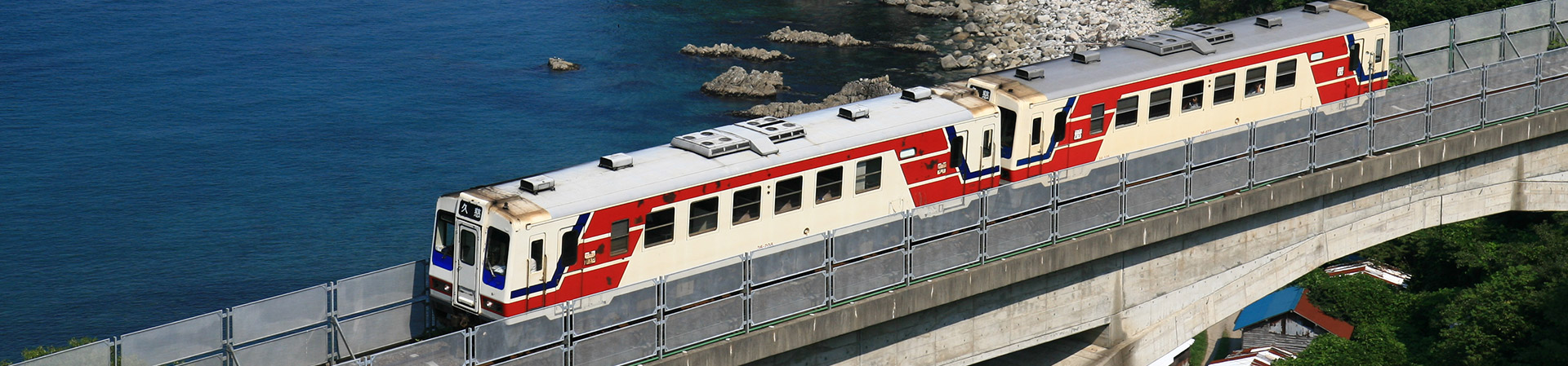 海辺の橋を電車が進んでいる写真